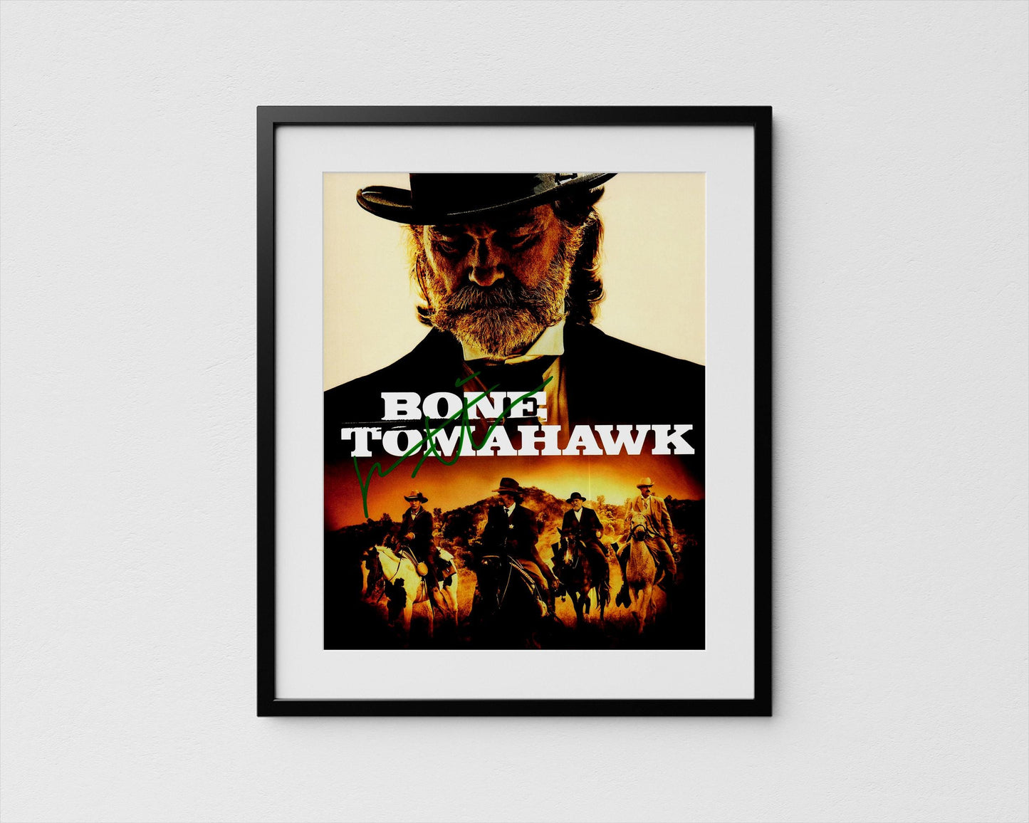 The image is a framed poster featuring a close-up of a man's face wearing a hat, with a cowboy hat and a bandana. The poster also includes a collage of other images depicting people on horseback, suggesting a western or cowboy theme.