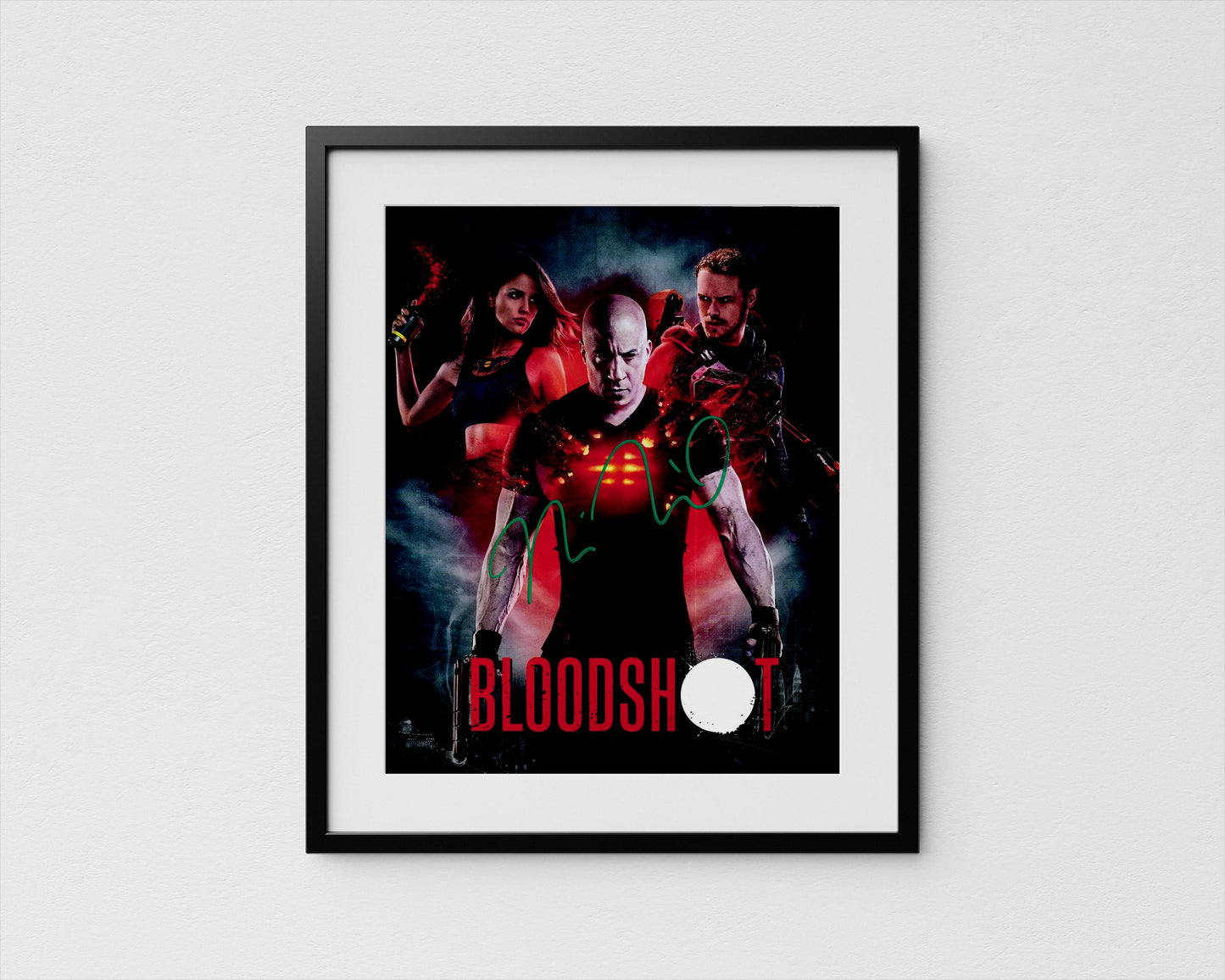 The image is a framed poster featuring a man with a serious expression, surrounded by two women in red outfits, with the word "BLOODSHOT" prominently displayed.