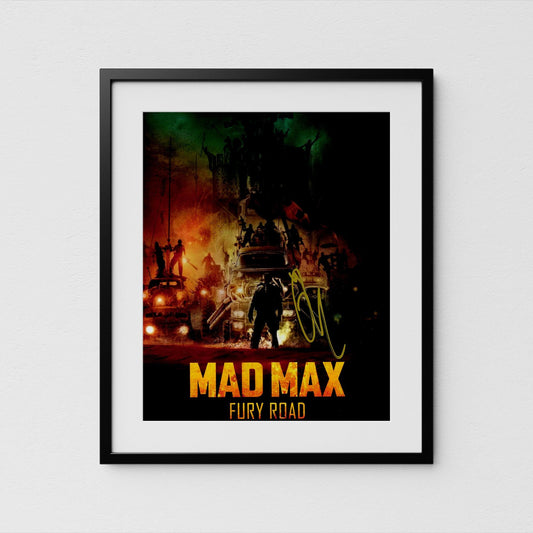 The image is a framed poster or artwork featuring a scene from the movie &quot;Mad Max: Fury Road&quot;. The poster has a dark, dramatic background with various vehicles and people, creating a sense of chaos and tension. The title &quot;Mad Max: Fury Road&quot; is prominently displayed in large, bold letters at the bottom of the poster.
