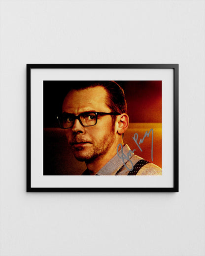 The image is a framed photograph of a man wearing glasses, with a signature in the corner.