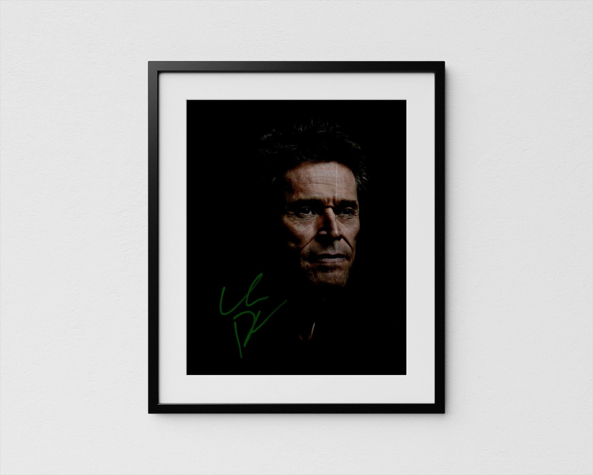 A framed portrait of Willem Dafoe with a serious expression, set against a dark background.