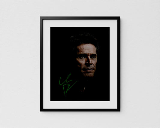 A framed portrait of Willem Dafoe with a serious expression, set against a dark background.