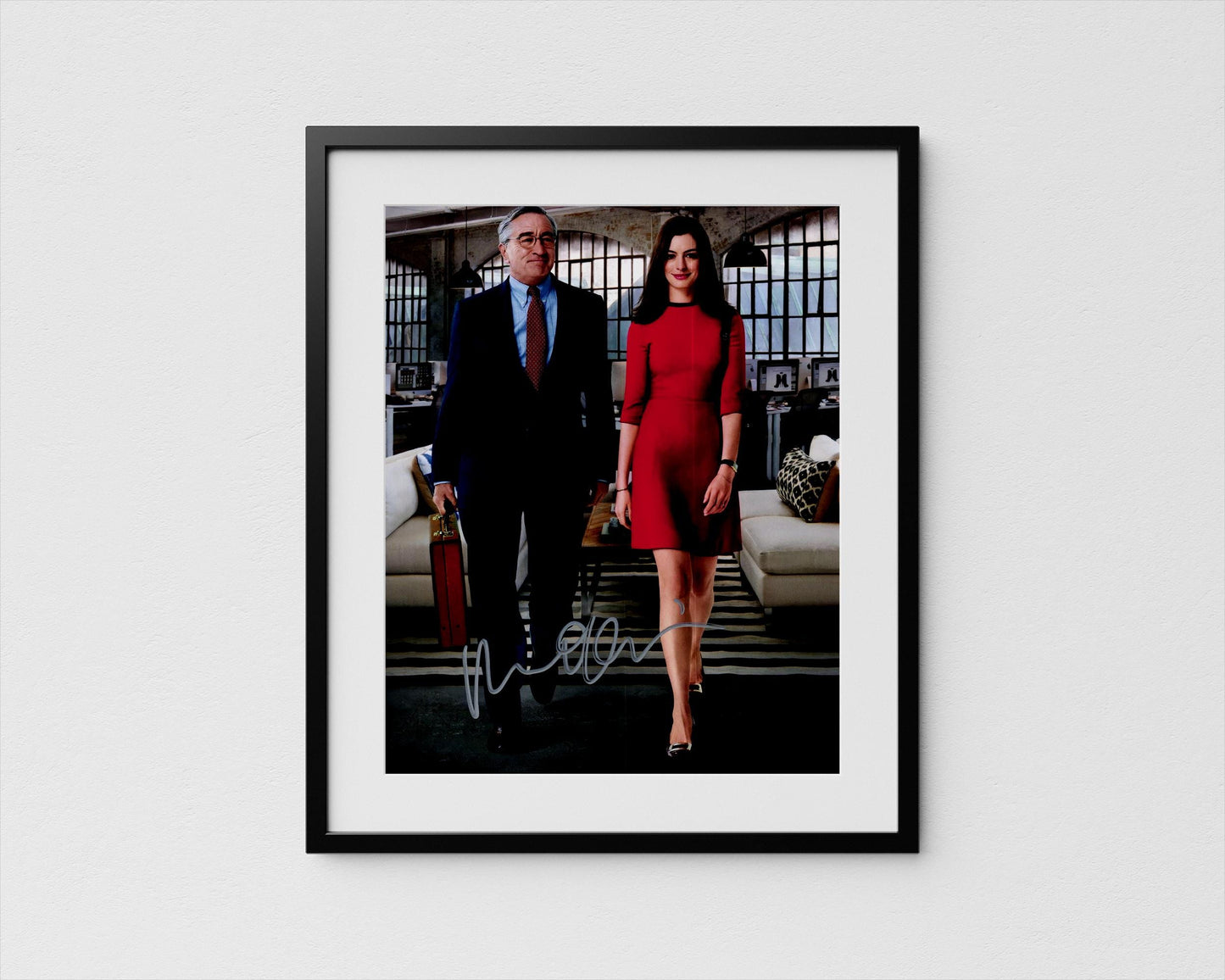 A framed photograph of a man and a woman dressed in formal attire, standing together in an office setting.
