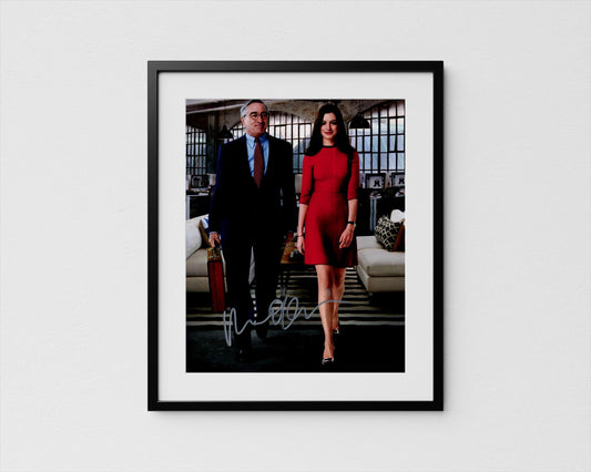 A framed photograph of a man and a woman dressed in formal attire, standing together in an office setting.