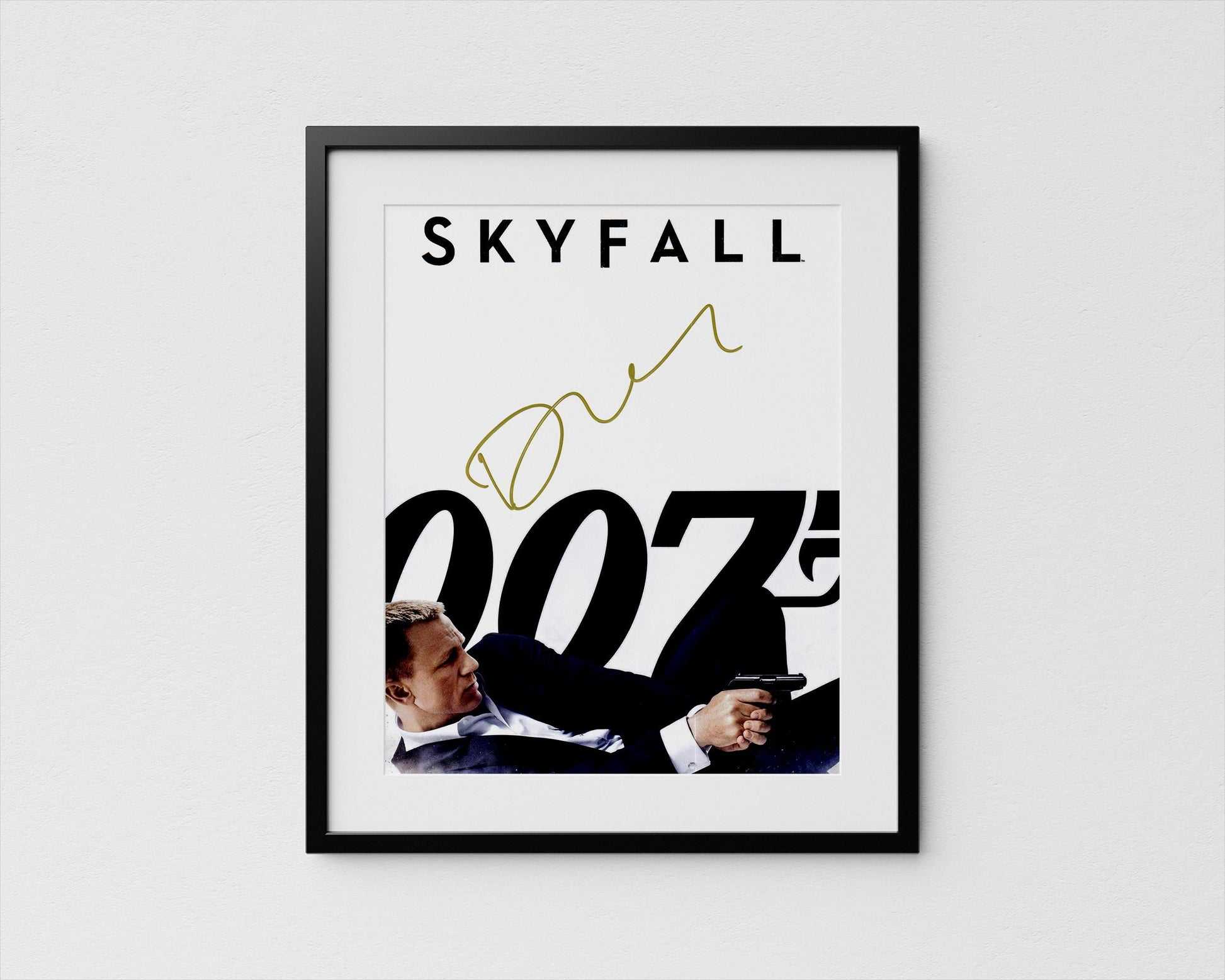 A framed poster featuring a man in a suit holding a gun, with the text &quot;SKYFALL 007&quot; prominently displayed.