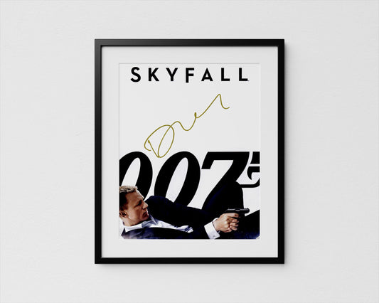 A framed poster featuring a man in a suit holding a gun, with the text &quot;SKYFALL 007&quot; prominently displayed.