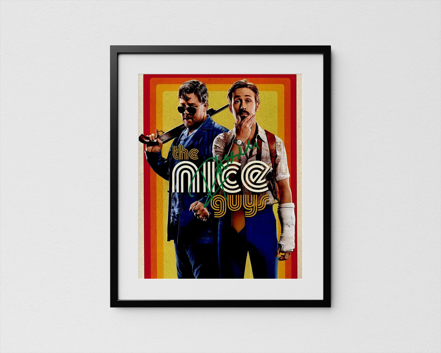The image is a framed poster featuring two men, one holding a gun and the other with a concerned expression. The text &quot;the nice guys&quot; is prominently displayed in the center of the poster.