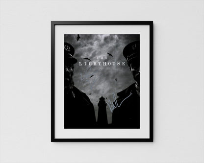 The image is a framed poster featuring two silhouetted figures, likely representing characters from a film or television show, with a lighthouse in the background.