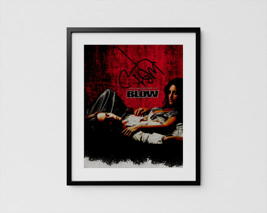The image is a framed poster featuring a woman lying down and a man lying next to her. The poster has a red and black color scheme and includes the text &quot;BLOW&quot; prominently displayed.