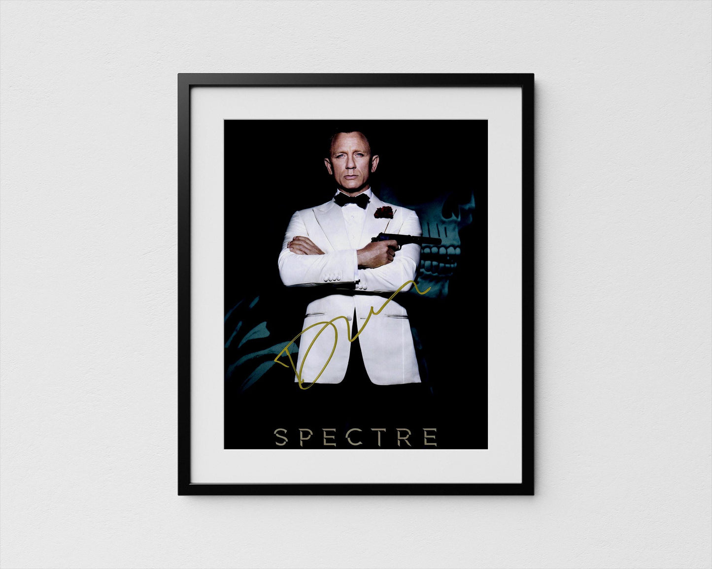 A framed poster featuring a man in a tuxedo with his arms crossed, holding a gun, against a dark background with a skull and green foliage.