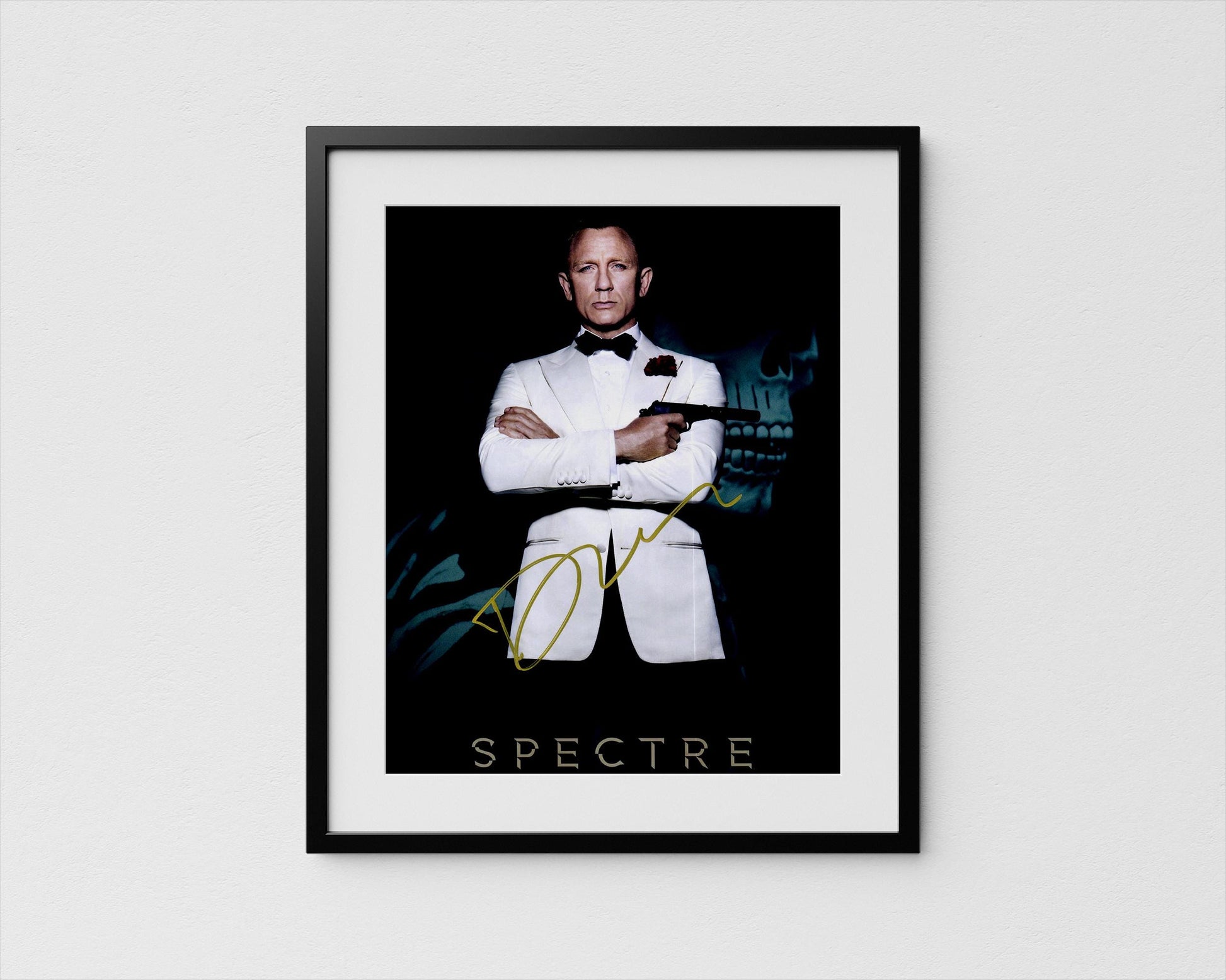 A framed poster featuring a man in a tuxedo with his arms crossed, holding a gun, against a dark background with a skull and green foliage.