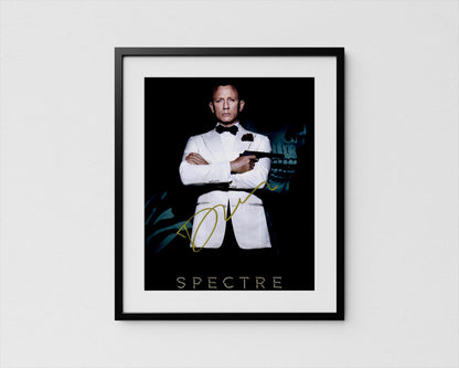 A framed poster featuring a man in a tuxedo with his arms crossed, holding a gun, against a dark background with a skull and green foliage.