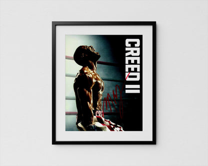 The image is a framed poster featuring a muscular man in a boxing ring, with the word &quot;CREED&quot; prominently displayed.