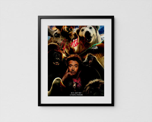 A framed poster featuring a man surrounded by various animals, including a polar bear, a gorilla, and a duck.