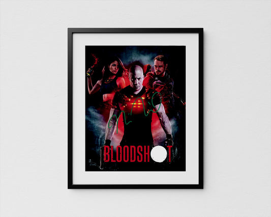 The image is a framed poster featuring a man with a serious expression, surrounded by two women in red outfits, with the word &quot;BLOODSHOT&quot; prominently displayed.